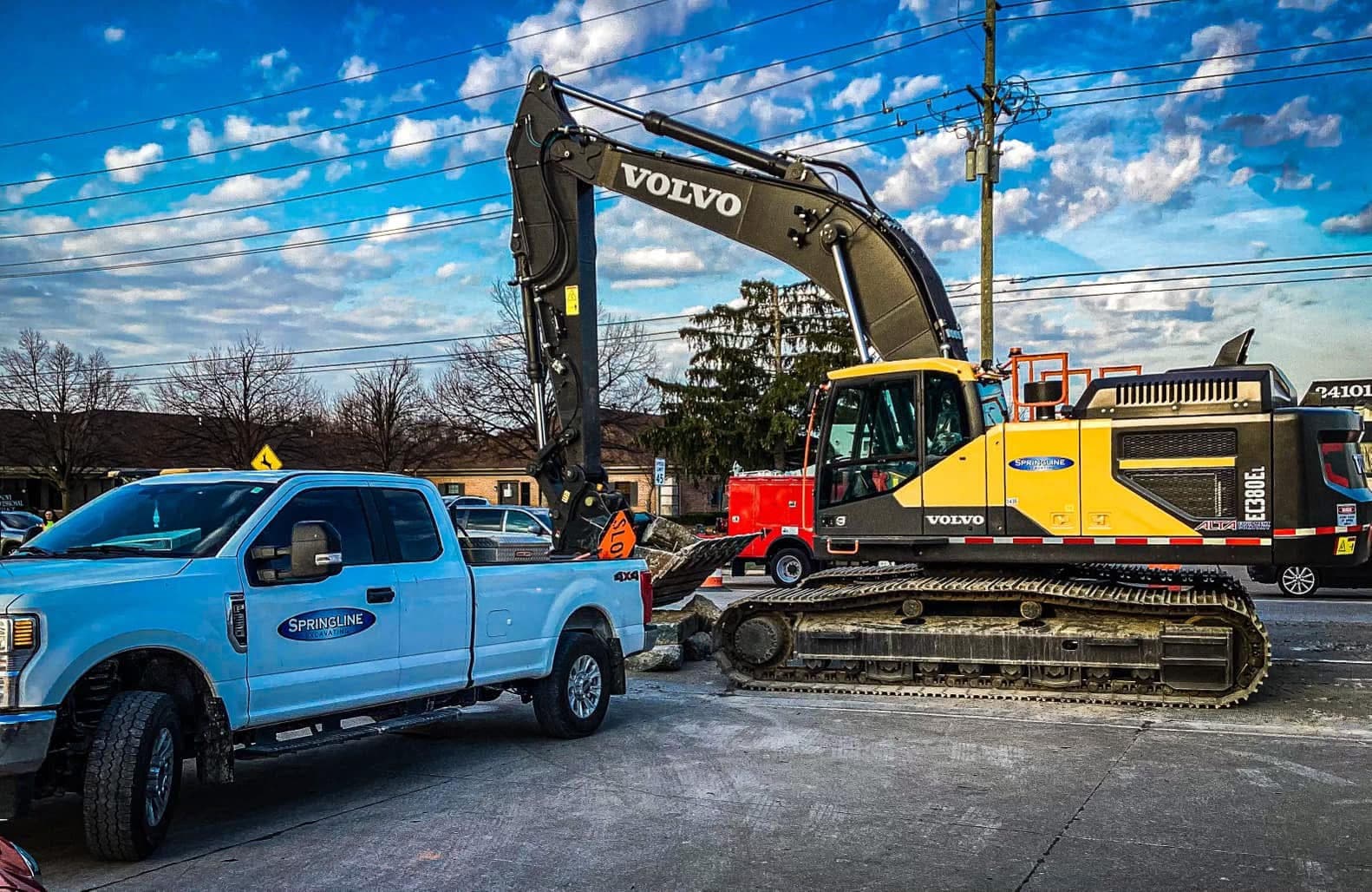 Heavy excavation equipment grading a road construction site at sunrise